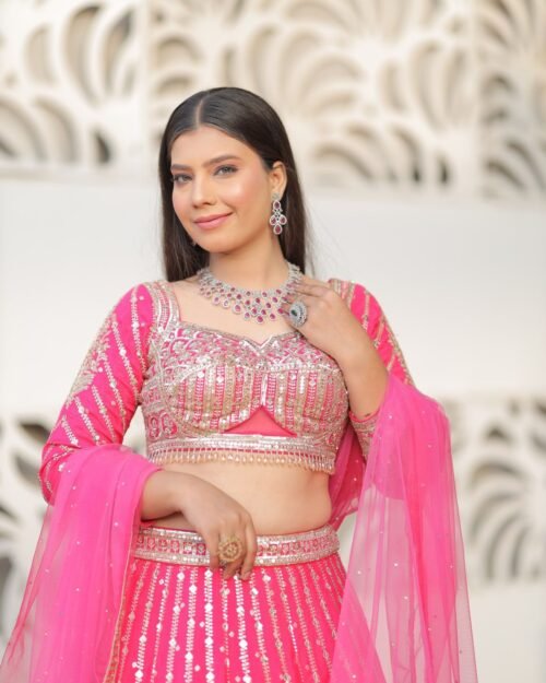 Model wearing a rose pink occasion outfit photographed outdoors