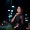 Model wearing a black saree photographed in evening light